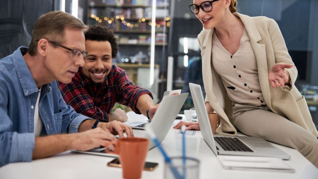 ludzie w biurze radośni przy komputerze